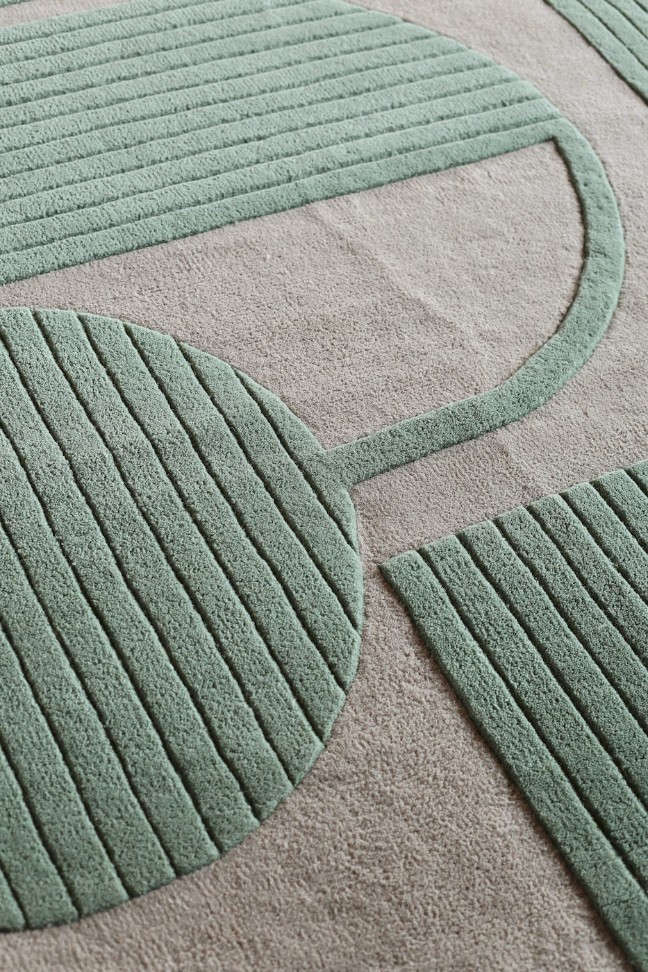Modern green wool rug with geometric shapes and carved lines